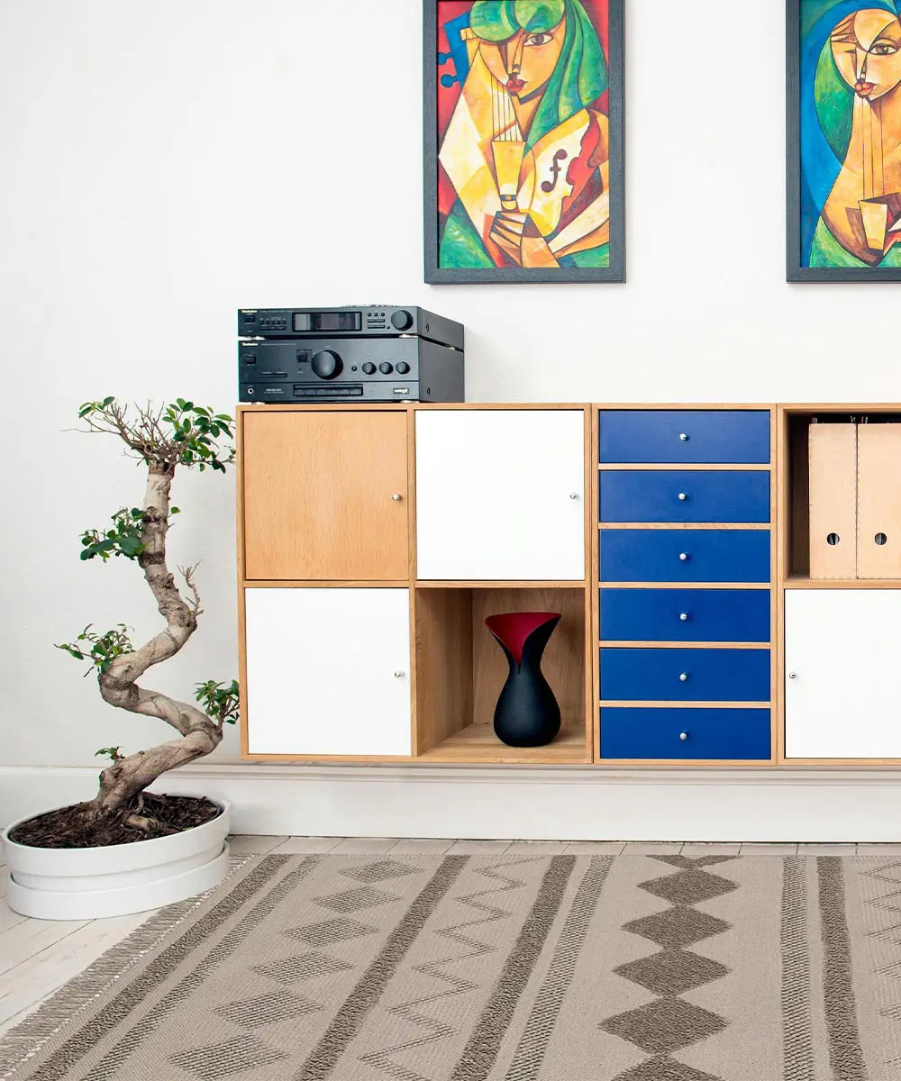 Tappeto berbero Taupe in cotone con geometrie marocchine in rilievo, colori avorio e sabbia, su pavimento chiaro con divano e tavolino dorato