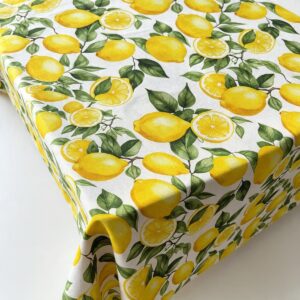 Tovaglia con fantasia limoni gialli e foglie verdi su fondo bianco, stile mediterraneo, ideale per tavola estiva