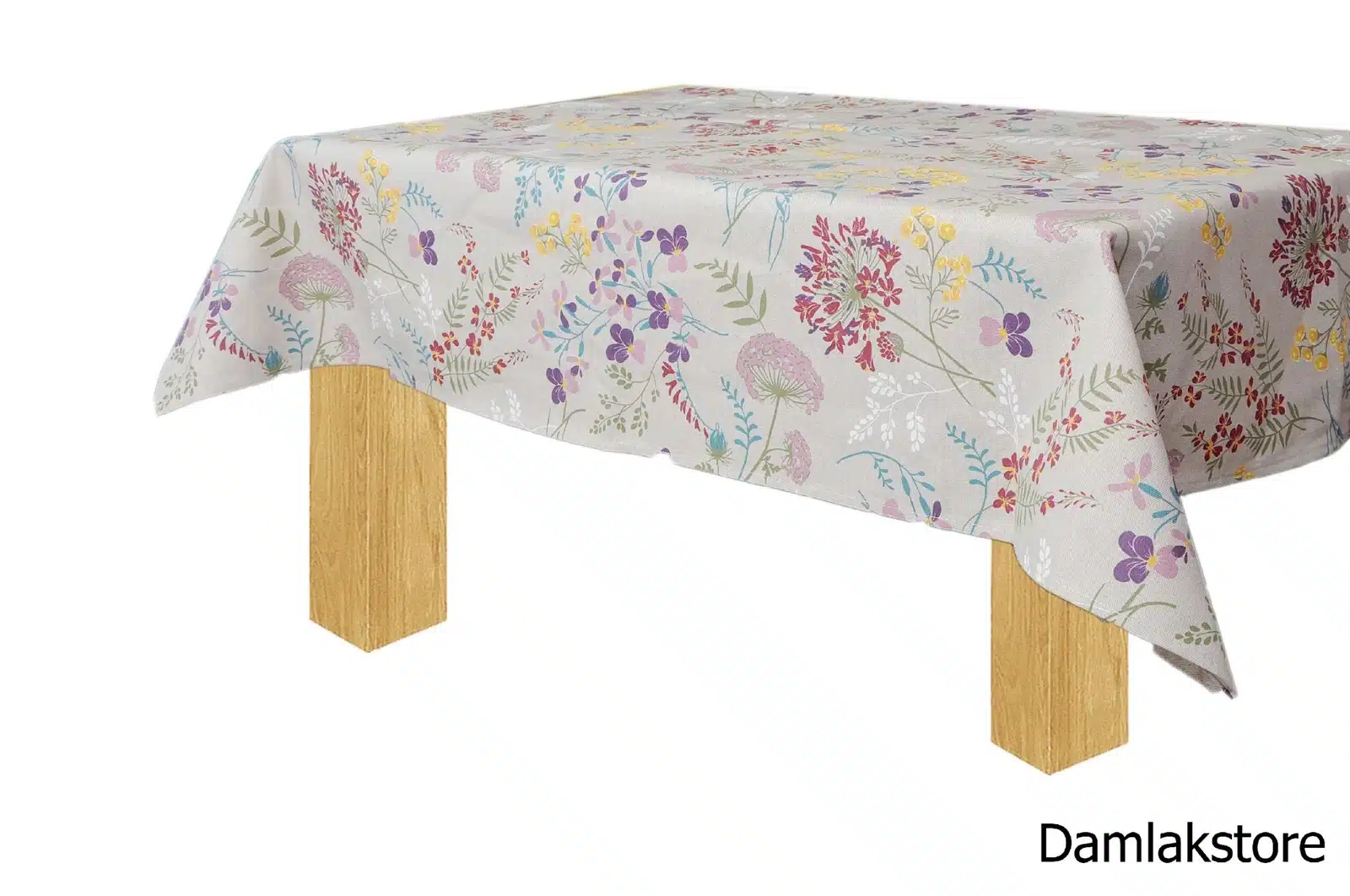 Tovaglia con fiori multicolore su fondo chiaro, vista laterale su tavolo in legno.