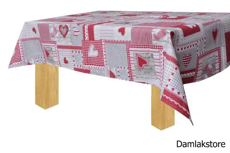 Tovaglia patchwork con cuori rossi, riquadri grigi e bianchi, vista laterale su tavolo in legno.