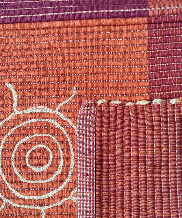 Dettaglio del ricamo a rilievo a punto catenella e della trama in cotone del tappeto Summer Rosso